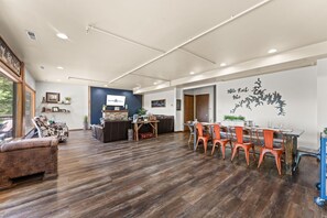 Un'ampia stanza con pavimento in legno, una scrivania della reception, un'area salotto con divano e poltrone, e una parete con una mappa decorativa.