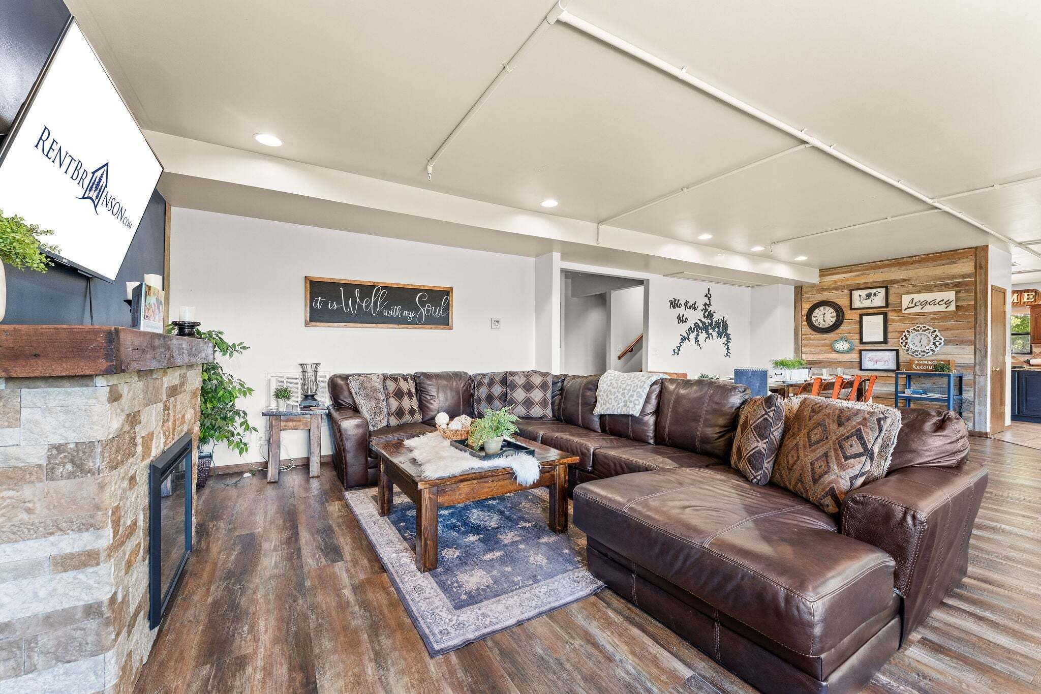 A modern living room with a fireplace, leather sofas, a coffee table, and decorative wall art.