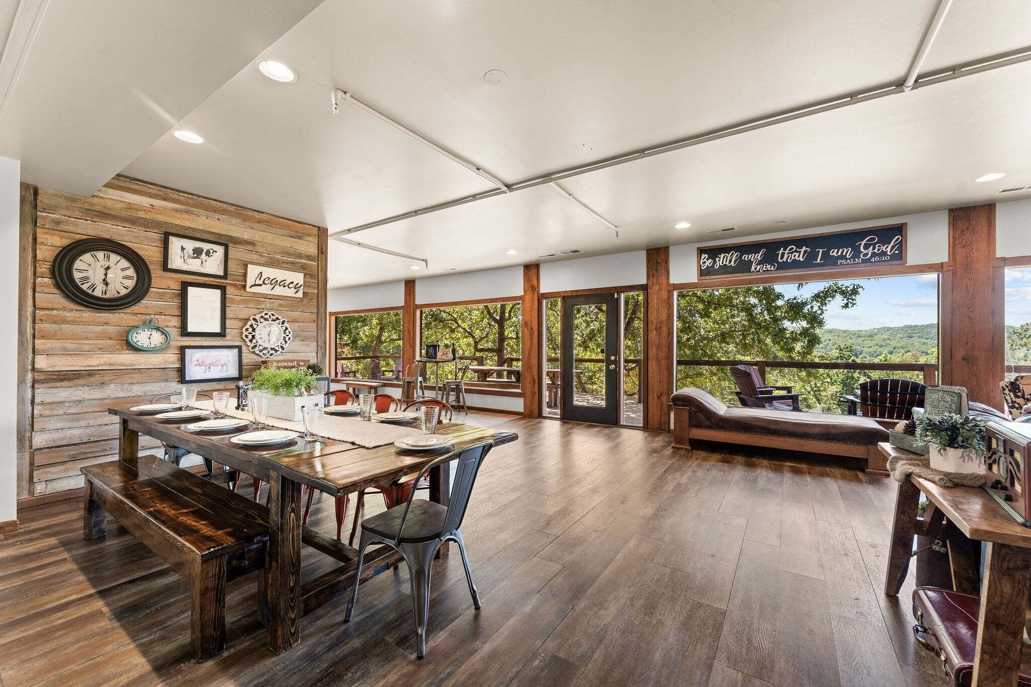 A spacious dining area with a wooden wall, a clock, and framed pictures.
