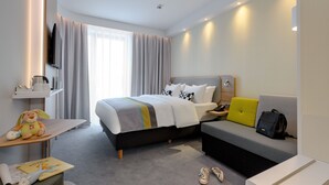 A modern hotel room with a bed, a sofa, a desk, and a TV. - Holiday Inn Express Fulda by IHG (Fulda)