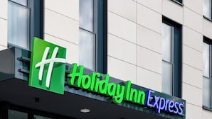 A Holiday Inn Express sign with a green logo and the name in white and purple letters. - Holiday Inn Express Fulda by IHG (Fulda)