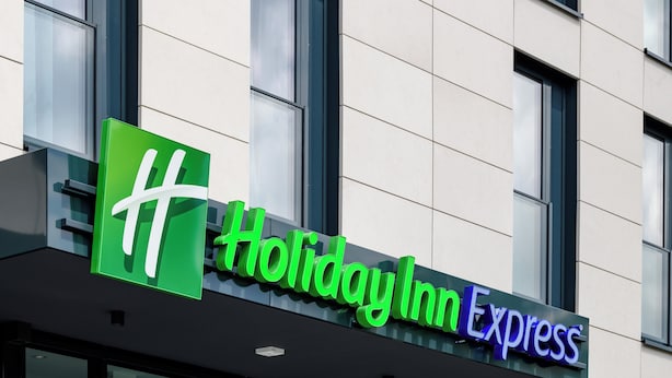 A Holiday Inn Express sign with a green logo and the name in white and purple letters. - Holiday Inn Express Fulda by IHG (Fulda)