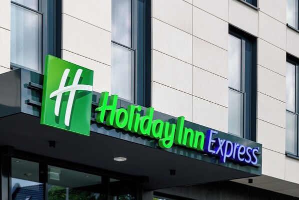 A Holiday Inn Express sign with a green logo and the name in white and purple letters.