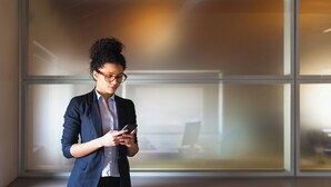A person in a business suit standing in a room with large windows and a blurred office background. - Holiday Inn Express Fulda by IHG (Fulda)