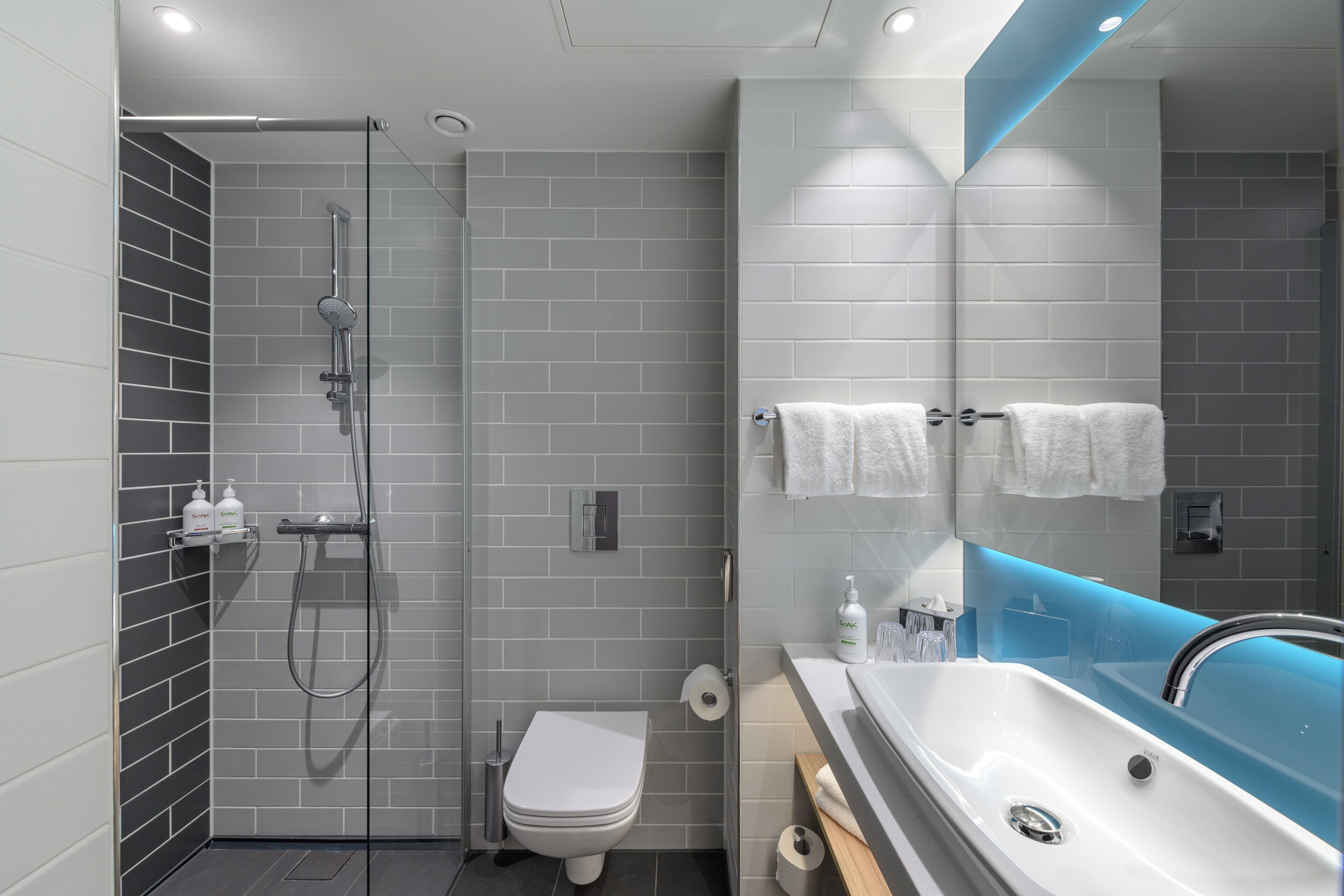 Un baño moderno con ducha, inodoro y lavabo.