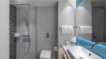 A modern bathroom with a shower, toilet, and sink.