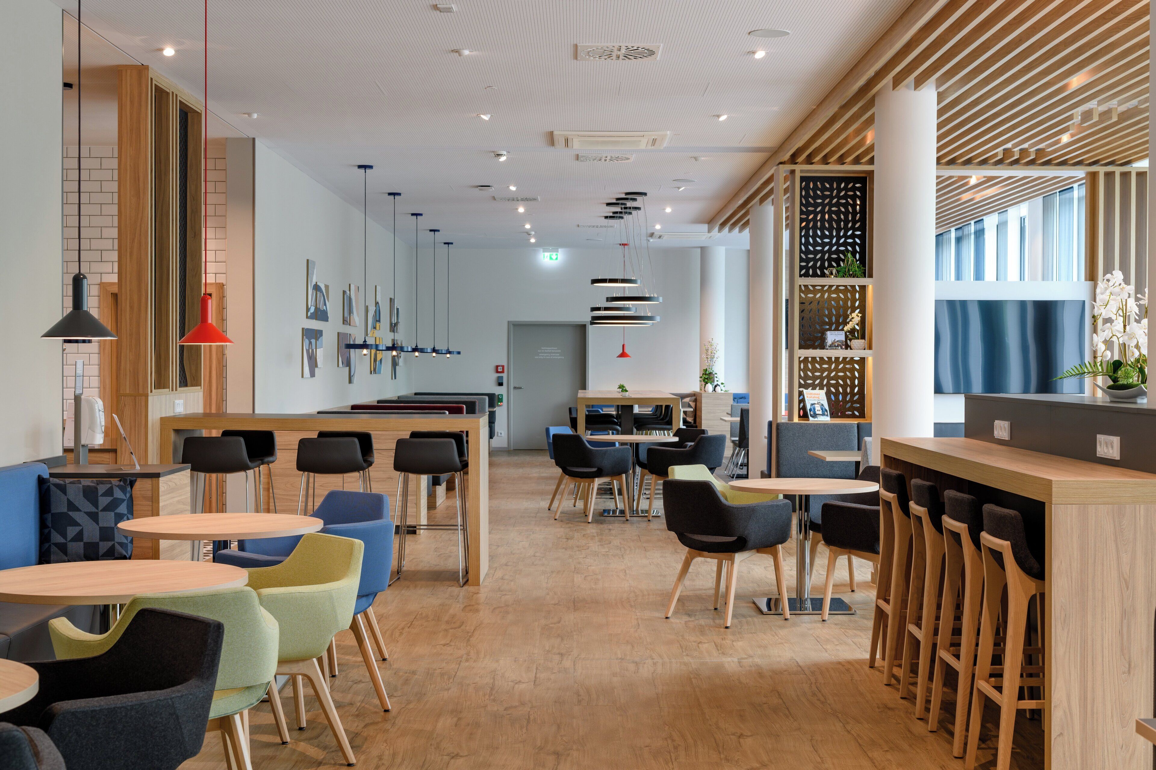 Un intérieur moderne avec un plancher en bois, plusieurs coins salon et un comptoir de bar.