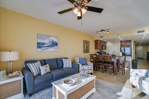 Uma sala de estar com sofá, mesa de centro e um espaço de jantar com cadeiras e uma mesa.