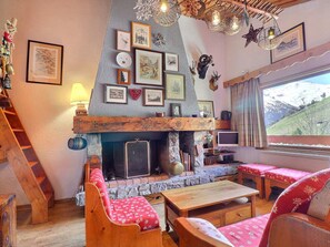 A cozy room with a fireplace, wooden furniture, and various wall decorations.