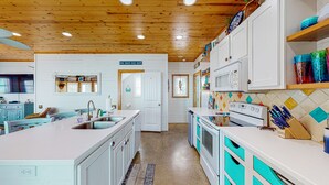 A kitchen with white cabinets, a large island, and a wooden ceiling. - Pet Friendly, 2 Shared Heated Pools, Parking for 3, Gated in Village Walk (Port Aransas)