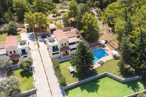 A residential area with multiple houses, a swimming pool, and a well-maintained lawn. - Dimitra - Seven Springs Villas (Archipoli)