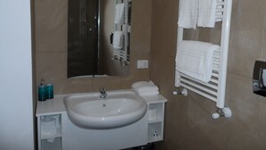 A bathroom with a sink, mirror, towel rack, and shower. - Appartamento con Camera da Letto e Balcone (Catania)