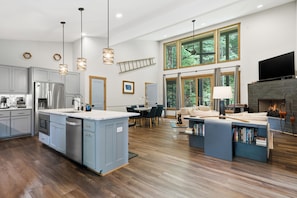 A spacious kitchen with modern appliances, a dining area with a large window, and a cozy living space with a fireplace.