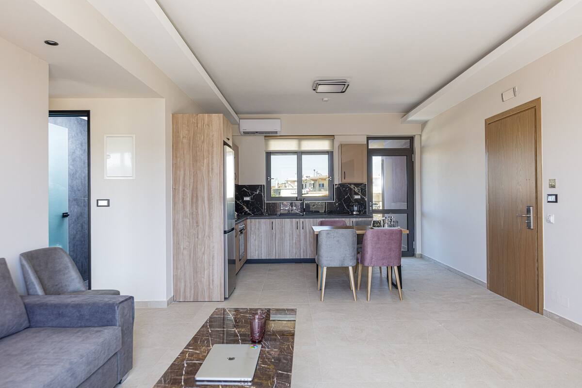 A modern apartment with a living room, a dining area, and a kitchen.
