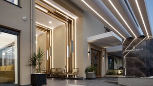 A modern hotel lobby with a reception desk, seating area, and a sign reading "Sapphire Suites". - Sapphire Blue Suites (Kissamos)
