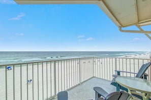 Ein Balkon mit Blick auf Strand und Meer.