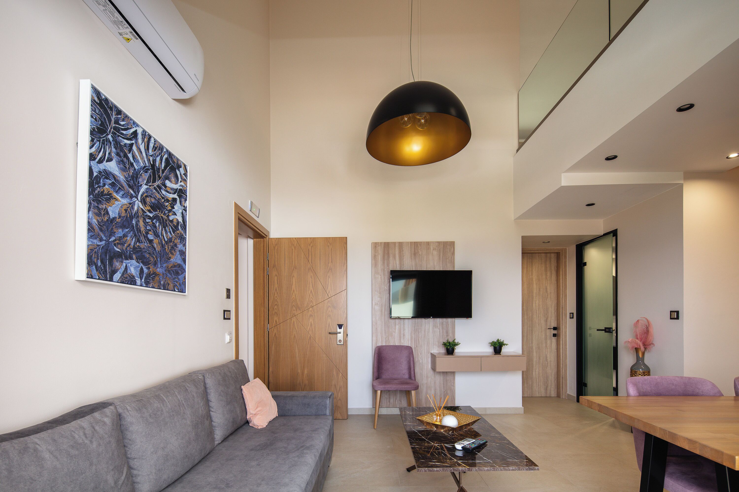 A modern living room with a grey sofa, a coffee table, and a large abstract painting.