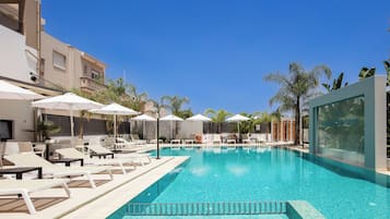 Una piscina al aire libre de temporada, sombrillas, tumbonas