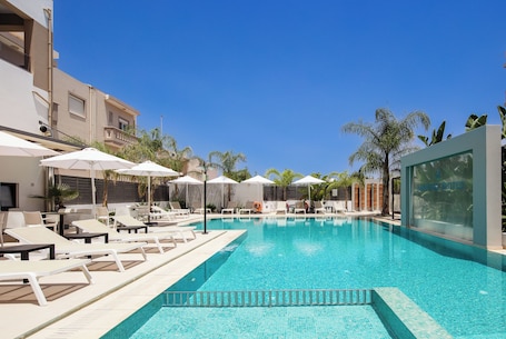 Una piscina al aire libre de temporada, sombrillas