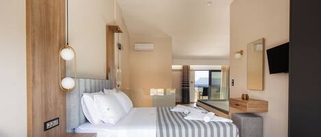 A modern hotel room with a bed, bedside table, lamp, and a television.