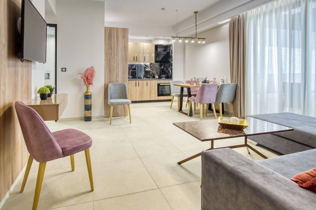 A modern living room with a sofa, chairs, a coffee table, and a dining area with a table and chairs.