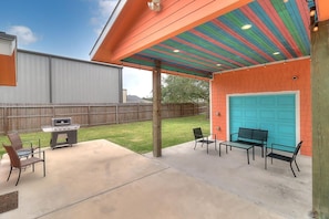 Une terrasse extérieure équipée d’un barbecue, de chaises et d’une table.