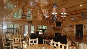 L’intérieur d’un chalet rustique comprend un coin repas, deux canapés et un bar.