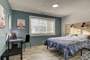 Relax in this inviting bedroom with a large bed, desk, and comfortable chair.