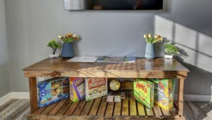 Una mesa de madera con juegos infantiles, libros, un globo terráqueo y pequeñas macetas.