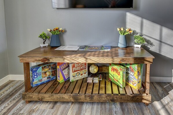 A wooden table with children's games and books, a globe, and small potted plants. - Updated 2 Bedroom Apartment A Stone's Throw From Downtown Omaha (Council Bluffs)
