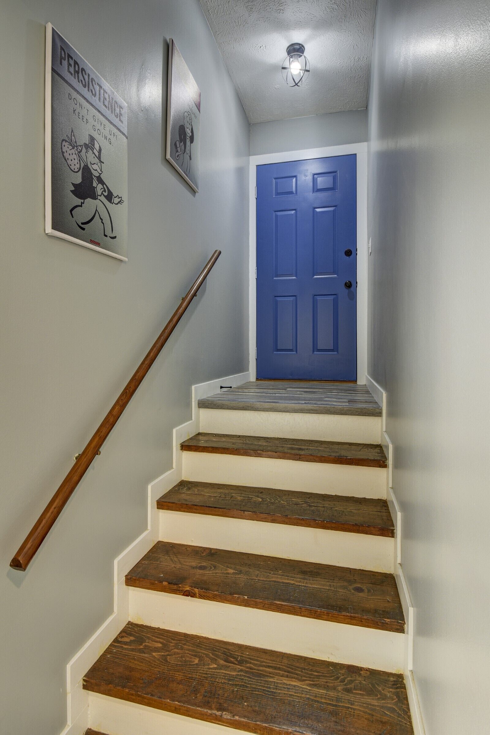 A staircase with wooden steps and a blue door at the top.