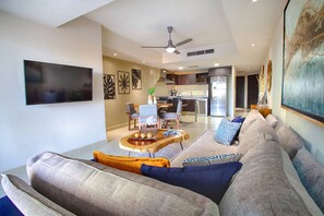Een moderne woonkamer met een bank, salontafel en een flatscreen televisie.
