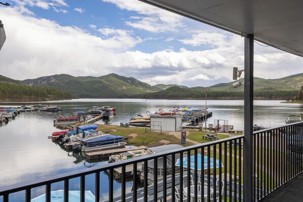 A marina with boats docked, a small building, and a view of mountains.