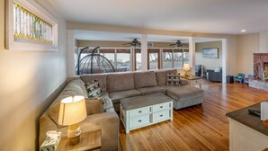 A spacious living room with a sectional sofa, a coffee table, and a fireplace. - Beautiful, Spacious, Beachfront Home - Perfect for Entertaining Family & Friends (West Haven)