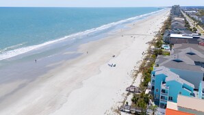 A beachfront hotel with a sandy beach, ocean view, and a row of buildings along the shore. - Oceanfront 5 BR Beach House in Surfside Beach with Private Pool! LA ESMERALDA II (Surfside Beach)