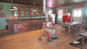 A rustic bar area with wooden cabinets, a vintage stove, and a 'Beer' sign on the wall. - Beer Joint at the Brown Ranch (La Grange)
