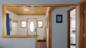 A hallway with a wooden ceiling, a white door, and a small window. - Lakehouse at Pillar Point on Lake Ontario, a relaxing home with stunning sunsets (Dexter)