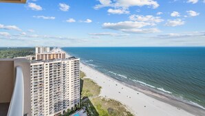 A high-rise building overlooking a beach with a clear sky. - 2507 Margate - 4 bedroom ocean front condo - (Myrtle Beach)