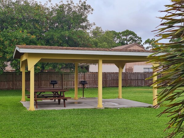 A covered picnic area with a bench and two barbecue grills. - The Perfect Shiny Condo (Sarasota)