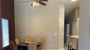 A dining area with a round table and wicker chairs, a ceiling fan, and a carpeted floor. - Bullhead City 3 Bedroom! Private Launch, & Beach! (Bullhead City)