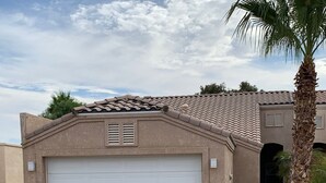 A single-story house with a garage, a tiled roof, and a palm tree. - Bullhead City 3 Bedroom! Private Launch, & Beach! (Bullhead City)