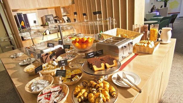 Een buffet met diverse gerechten, waaronder gebak, brood en een schaal mandarijnen.