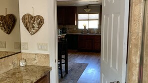 A kitchen with wooden cabinets, a granite countertop, and a heart-shaped decoration on the wall. - Beautiful and Relaxing Guest House!! (Redding)
