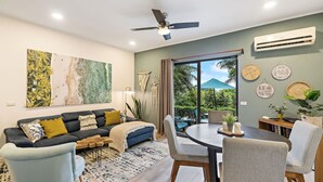 A modern living room with a sofa, coffee table, and dining area. - Stylish + Fast Wifi+ IPTV+ Fully Equipped (Tamarindo)