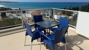 A balcony with a glass railing, blue chairs, and a table. - Villa Aqua Sunrise 1km From Beach With Sea Views (Coral Bay Peyia Paphos)