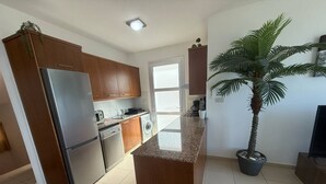 A modern kitchen with wooden cabinets, stainless steel appliances, and a central island. - Villa Aqua Sunrise 1km From Beach With Sea Views (Coral Bay Peyia Paphos)
