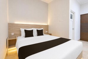 A hotel room with a bed, bedside tables, and a door. - Collection O Near Ambarrukmo Plaza Mall Formerly Damar Kusumo Guest House (Depok)
