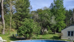 An above-ground swimming pool with a built-in ladder, surrounded by a gravel border and grass.