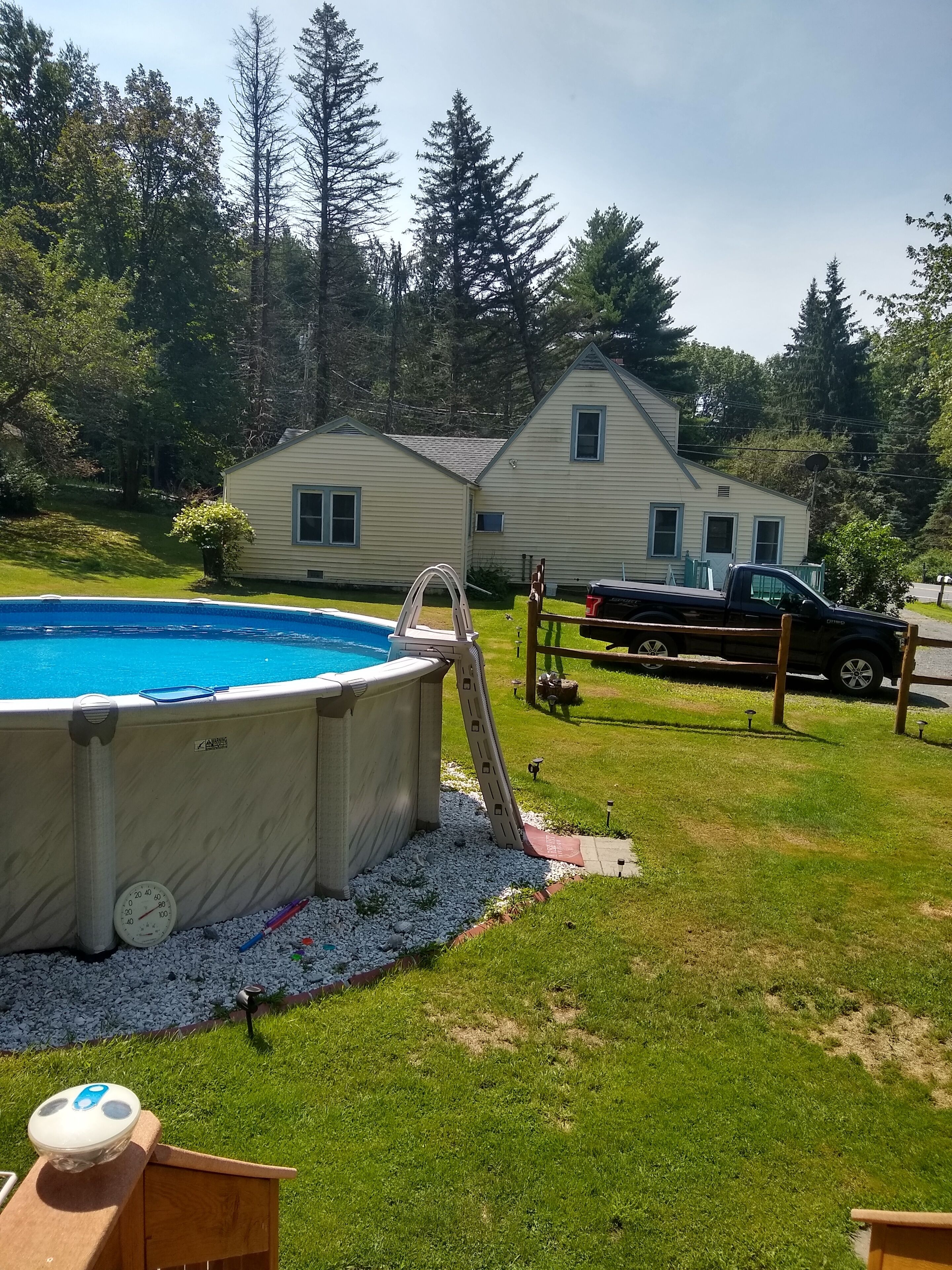 Ein Garten mit Schwimmbad, Whirlpool und überdachter Terrasse.
