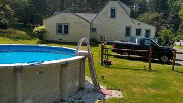Ein Garten mit Schwimmbad, Whirlpool und überdachter Terrasse.